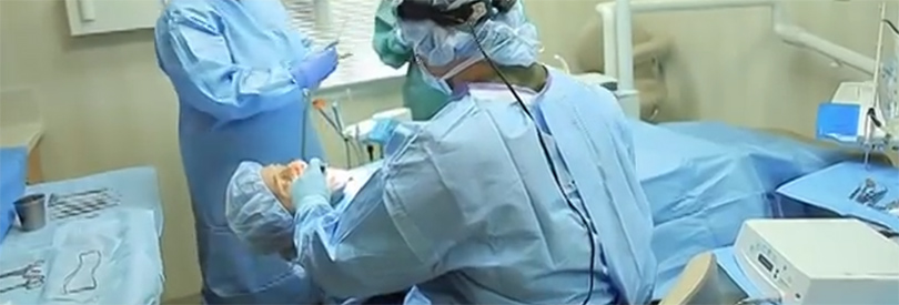 Two doctors practicing sedation dentistry on a patient laying down