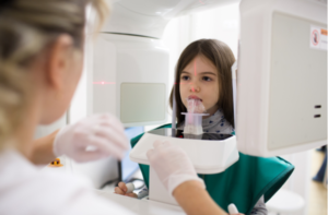 little girl patient doing panoramic teeth x-ray in dental clinic