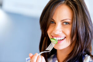 Young woman holding a fork eating