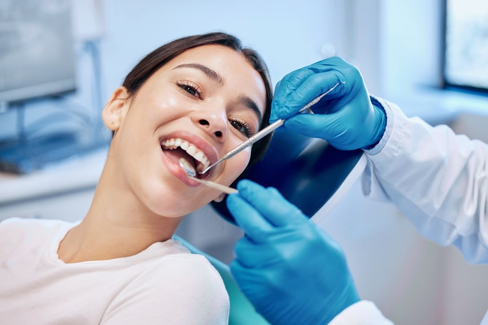 A woman smiling while getting a full mouth reconstruction in Long Island, NY