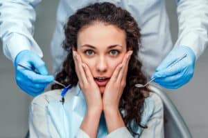 A woman with dental anxiety sitting in a dentist's chair