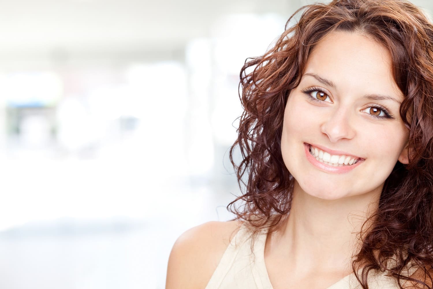 A woman smiling after getting her teeth whitened