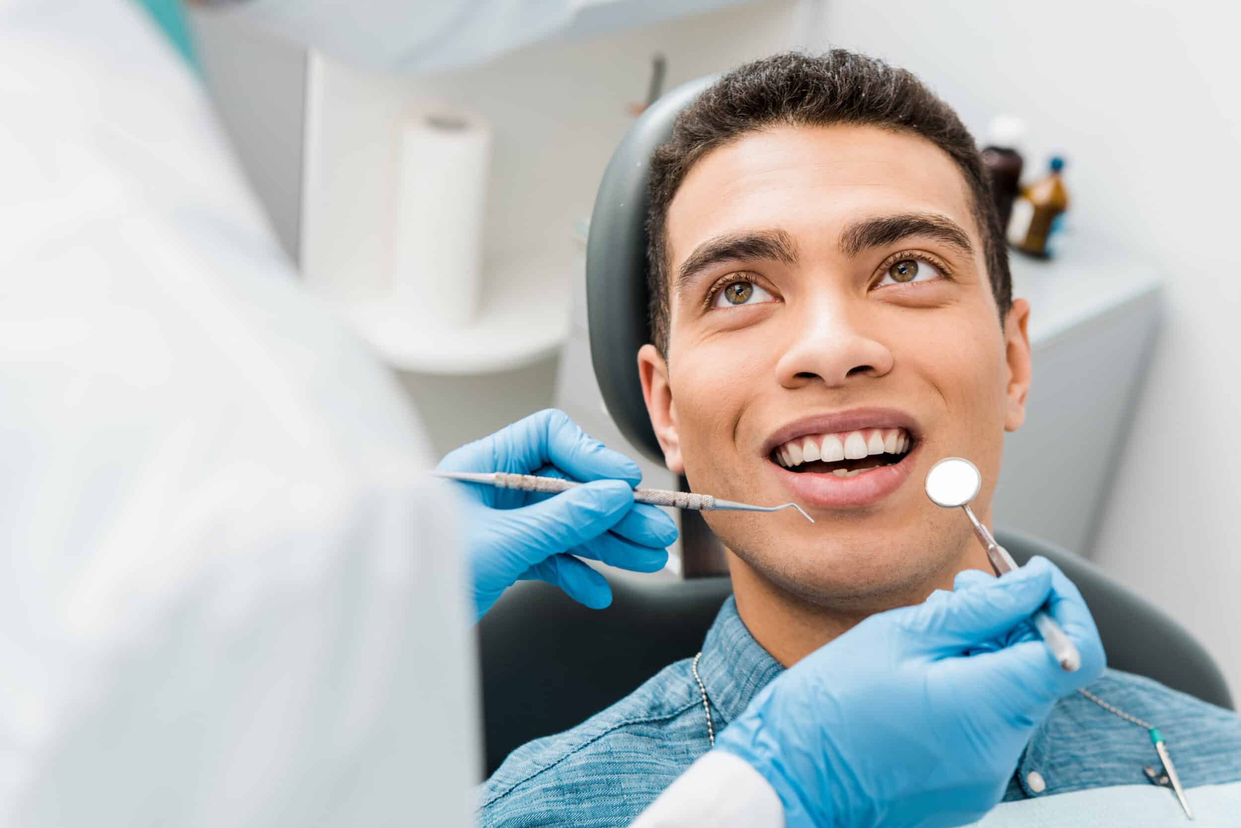 A man sitting in a dentist's chair during a root canal in Melville