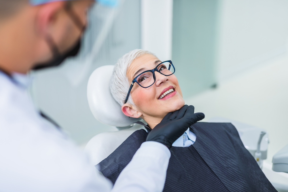 woman receiving treatment from qualified implant dentist