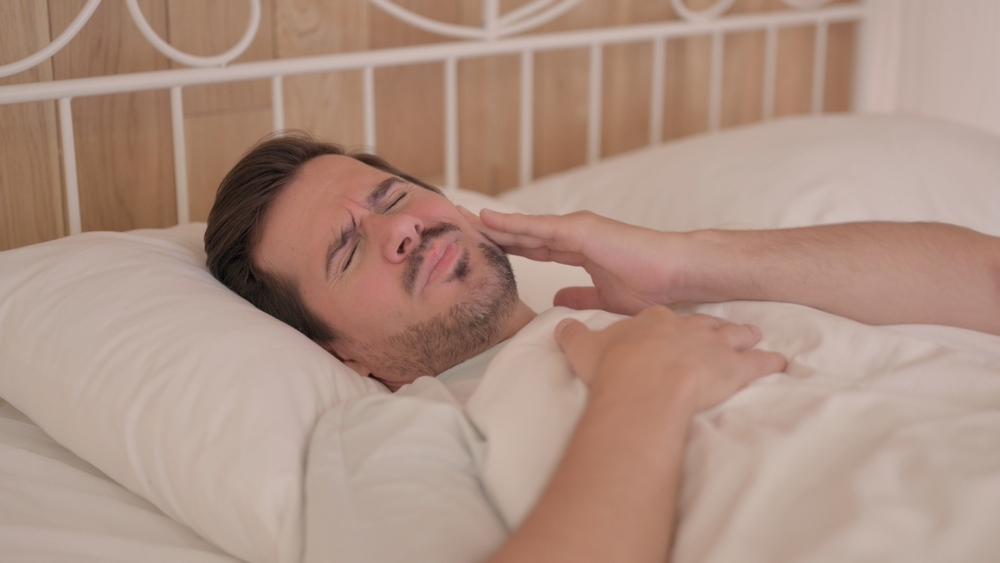 man experiencing dental pain at night